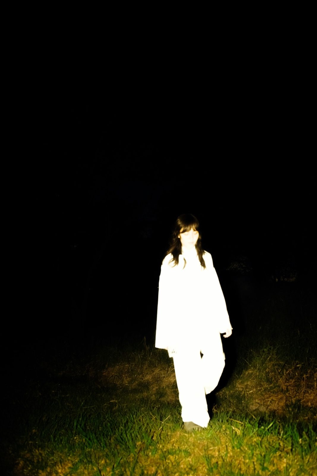 Dark analog flash photograph of a figure at night